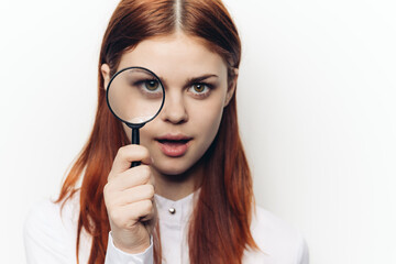 pretty woman grimacing with magnifying glass near face