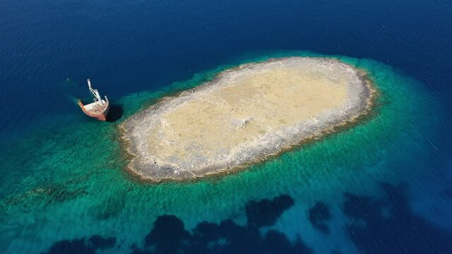 Aerial drone video of famous shipwreck of "Nordland" half sunk ship in islet of Prasonisi near Diakofti main port of Kithira island, Ionian, Greece