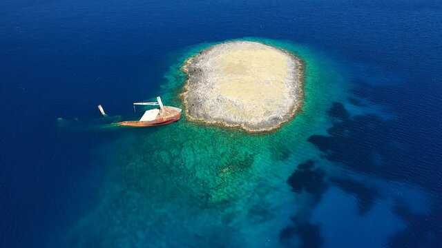 Aerial drone video of famous shipwreck of "Nordland" half sunk ship in islet of Prasonisi near Diakofti main port of Kithira island, Ionian, Greece