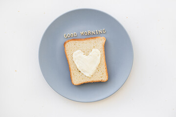 sandwich for breakfast in form of heart with cheese on a blue plate inscription good morning