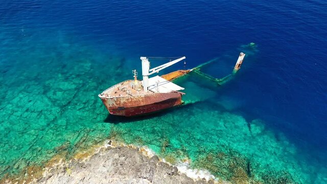 Aerial drone video of famous shipwreck of "Nordland" half sunk ship in islet of Prasonisi near Diakofti main port of Kithira island, Ionian, Greece