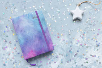 2022 yearly journal, chocolate and stars decoration on desk workspace, blue background. Winter holidays Christmas and New Year To Do List and lifestyle concept. Flat lay, top view, copy space