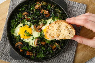 Woman eating tasty Shakshouka at table
