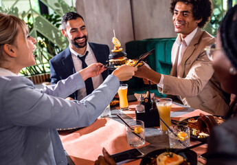 Group of people sitting in a restaurant at a business lunch.	