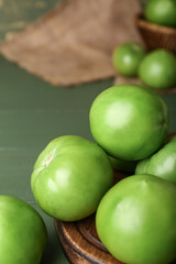 Fresh tomatoes on green wooden background