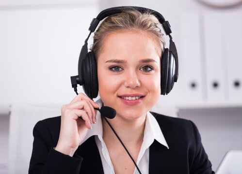 Portrait of smiling female customer support phone operator at workplace