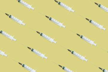 Seamless pattern with medical syringe and needle on yellow background