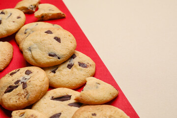 Delicious cookies with chocolate chips on color background, closeup