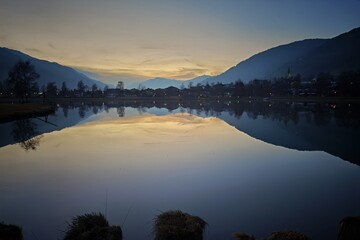 beautiful sunset with view over a still lake with a wonderfull reflection the mountains on the lake