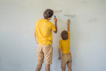 Father and son painting a wall in their home do it in the course of moving in