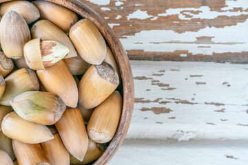 hazelnuts in a bowl on a wooden table