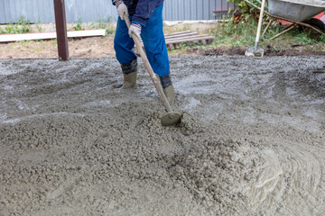 Workers level out the concrete mix at a construction site.