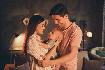 Portrait of attractive idyllic cheerful family parenthood cuddling toddler late night at home house flat indoors