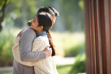 young asian couple hugging outdoors - obrazy, fototapety, plakaty
