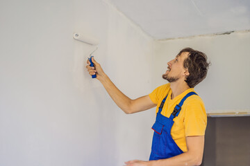 Professional painter worker painting and priming wall with painting roller