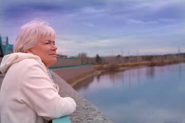 Fototapeta na wymiar Day dreaming senior woman outdoors. Contented senior woman looking thoughtful during walking countryside