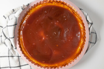 Classic cheesecake with caramel sauce on white plate on gray background. Copy space for text.