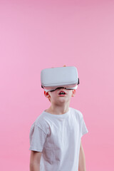 Schoolboy wearing virtual reality device on pink background