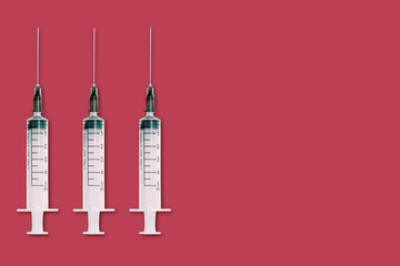 Medical syringe and needle on red background with space for text