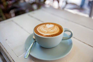 Blue cup of coffee on white rustic background with beautiful latte art