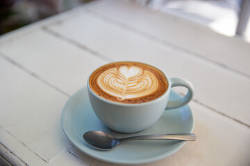 Blue cup of coffee on white rustic background with beautiful latte art