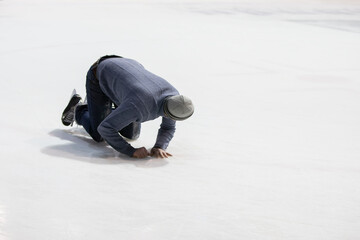 Fototapeta na wymiar The man fell while skating on the ice.