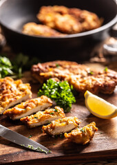 Traditional Viennese chicken Schnitzel on a wooden board.
