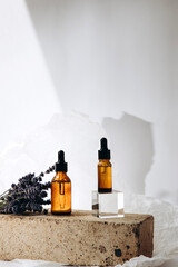 Serum on a podium made of bricks on a white background. Serum and lavender bunch. Front view