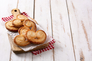 Palmier puff pastry on white wooden table. Copy space