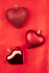 Valentines day background with tree red hearts on a red silk material, red Valentines background