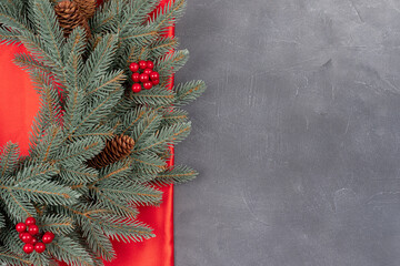 Christmas border on red silk background with gray concrete backdrop. Top view and flat lay with copy space for invitation text
