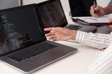Fototapeta premium co-working concept the female wearing white vertical striped blouse reporting the subject on her computer while her partner writing it down on the paper