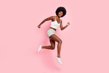 Fototapeta na wymiar Full length body size photo girl smiling jumping up running on sale isolated pastel pink color background