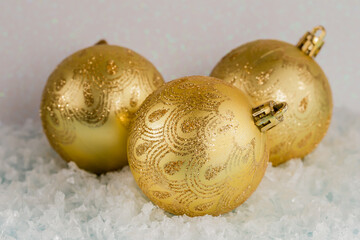 Golden Christmas balls on the snow