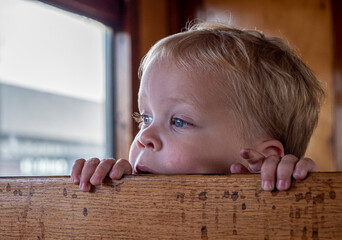 Little boy is waiting for the departure in the steam train at the VSM in Beekbergen.