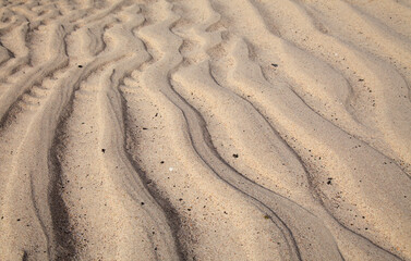 natural sand pattern created by a flow of tide and ripples on the edge of a beach