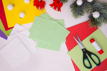 Paper napkins, scissors, colored paper on a light table. Children's Christmas craft. Step-by-step instruction. Step 1.
