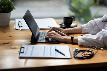 Medical technology concept. Close up doctor working with digital tablet and and medical stethoscope on the desk at workplace. Online medical,medic tech, emr, ehr concept