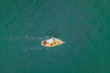 Aerial bird's eye view photo taken by drone of sailboat in turquoise sea water