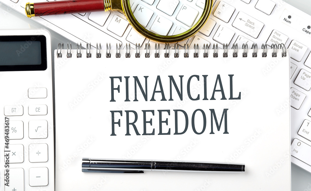 Poster financial freedom text on notepad with calculator and keyboard,business concept
