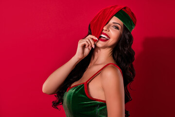 Photo of playful mistress cover eye tease boyfriend foreplay wear hat elf costume isolated red color background