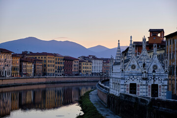 the church of Pisa, tuscany, italy, beside the river and the reflection of the colorful houses