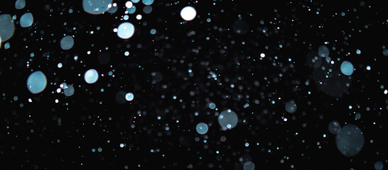 Blurred snowflakes on a dark background. Overlay image for snowfall effect