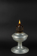 A lit kerosene lamp in front of the Gray background.