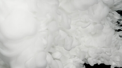 White acrylic paints in water on a black background. Beautiful milky white