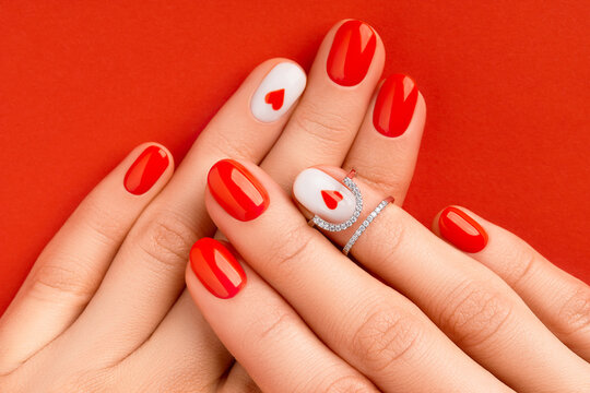 Womans hands with fashionable red manicure. Valentines day nail design