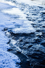 Frozen ice and snow on the river bank.  Frozen mountain stream. River in ice. 