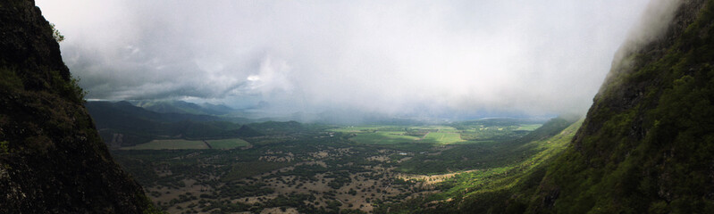 Fototapeta premium Panoramic view from top of 'Trois Mamelles' mountain during a rainy and misty day in Mauritius