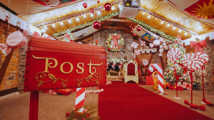 Closeup Red post box for letters to Lapland to Santa Claus. Christmas tradition. Decorative mailbox Santa Claus workshop, wrapped gifts presents boxes on holiday eve in night on xmas background © GRAFStock