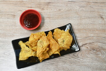 crispy fried dumpling paste stuffed chop pork dipping sweet chili sauce on plate